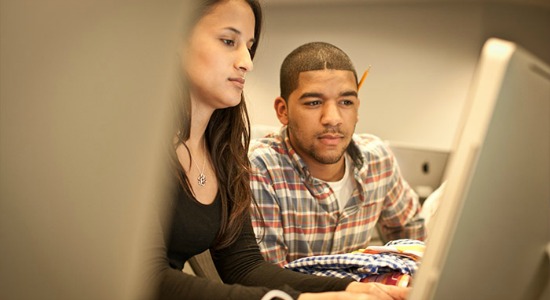 Two students reviewing business analytics