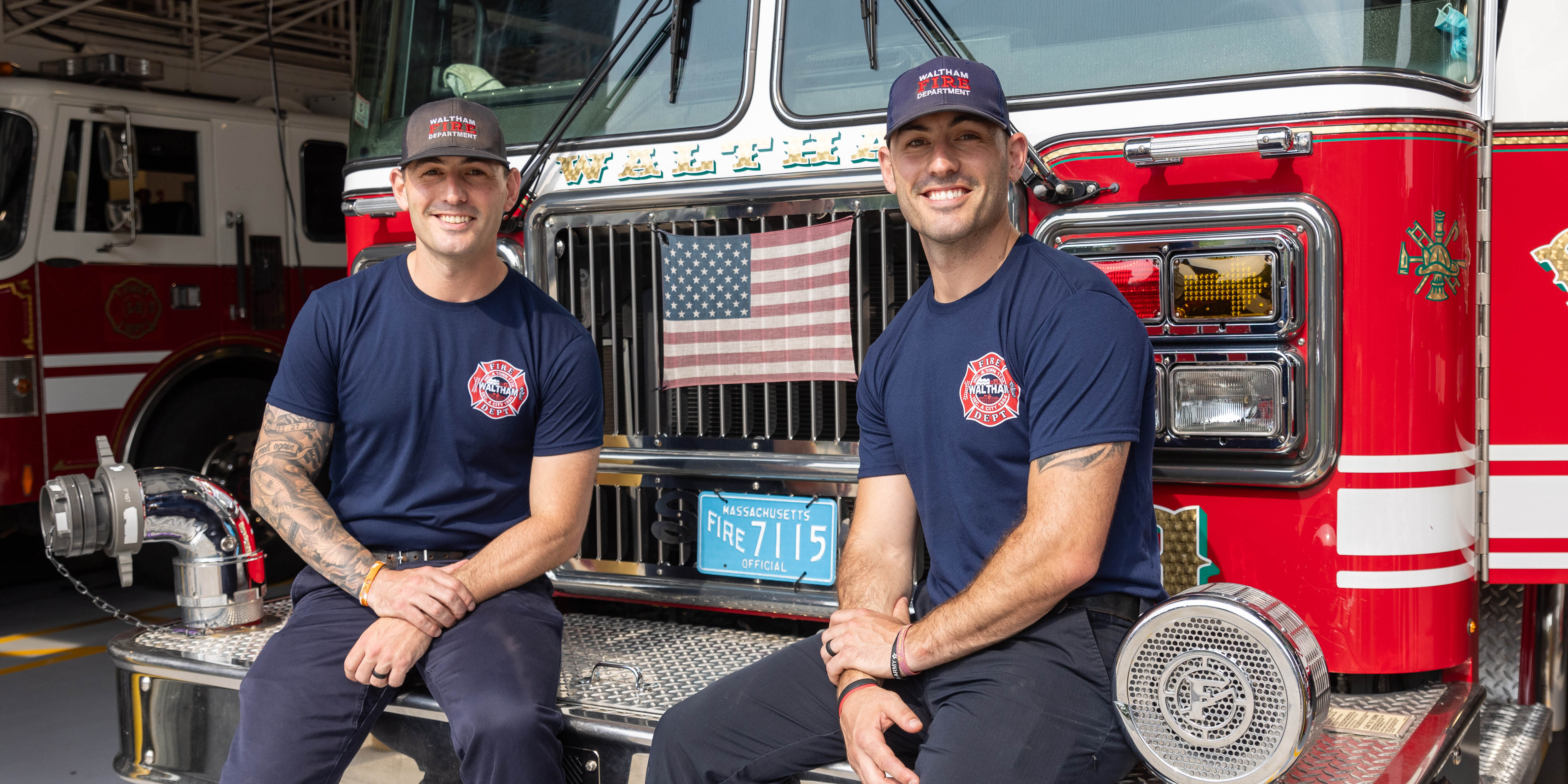 Steve ’12 and Don ’12 Hopkins sit in front of a fire truck