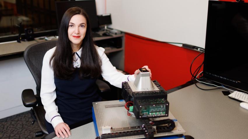 Professor Mounia Ziat sits at table, upon which is the machine she will use to test edge perception. 