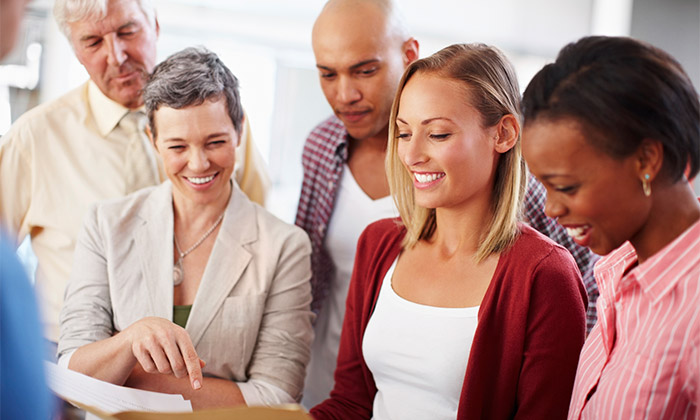 smiling people looking together at a document