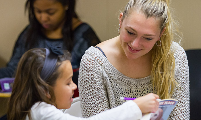 Young woman helping a child