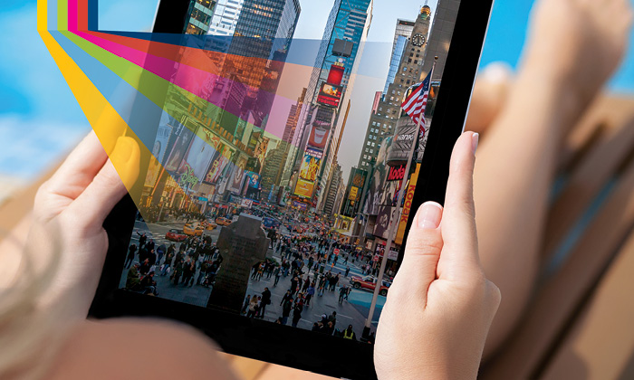 Tablet with cityscape on it and rainbow graphic overlay