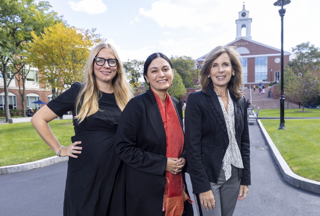 2022 Outstanding Scholarly Contribution Award recipients — from left to right, Marieke Mohlmann, Angma Jhala, and Cynthia Clark — pose together on the Bentley campus, with the library and bell tower in the distance.