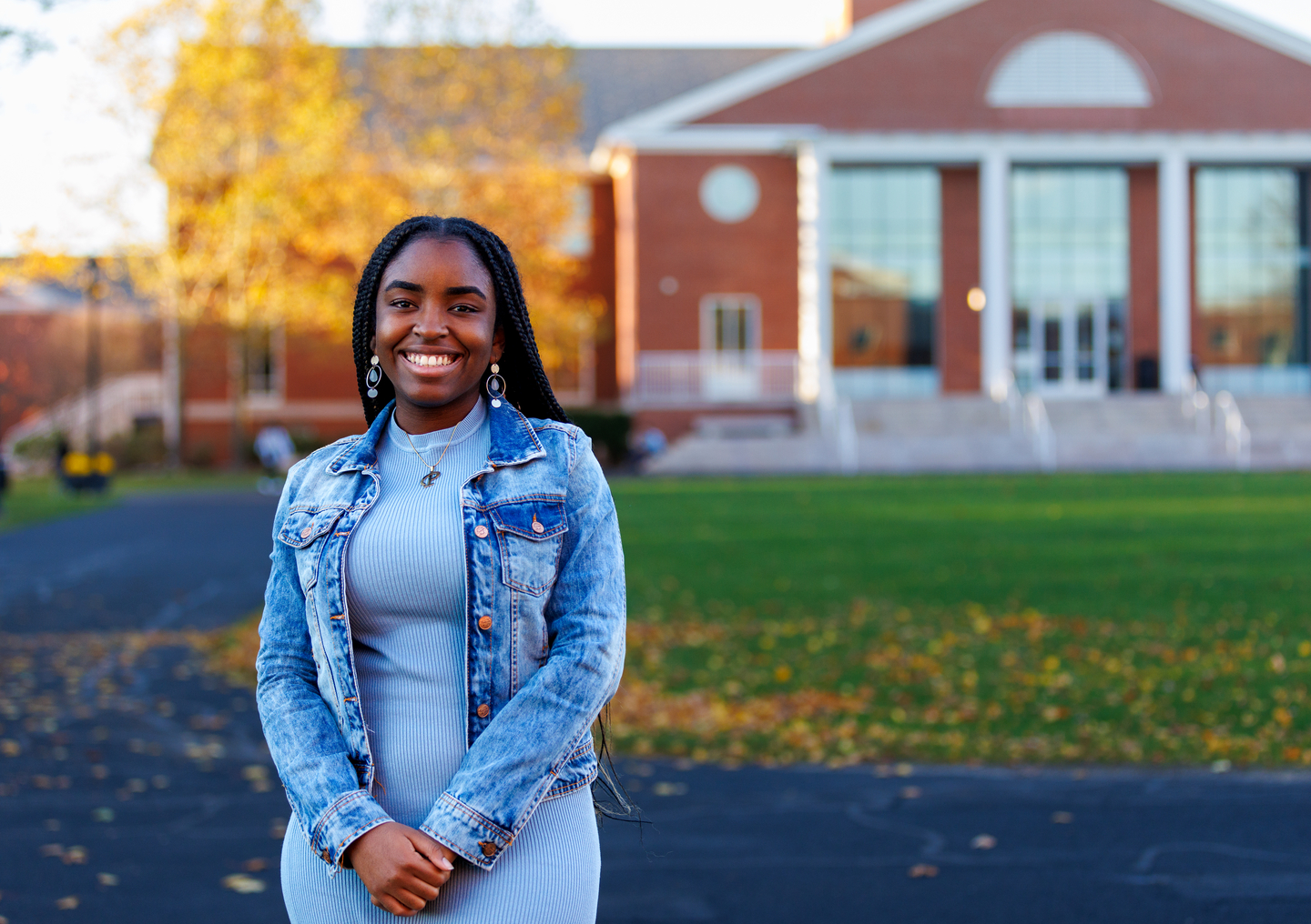 Pearl Opara wearing blue dress with denim jacket in front of Bentley library