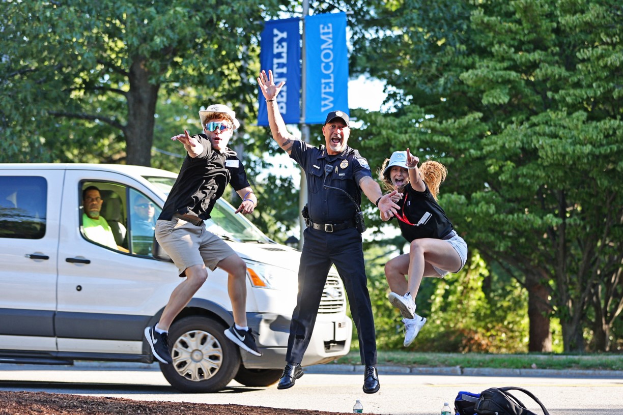 Police chief Frank Bourgeois and two student orientation leaders jump for joy on move in day.