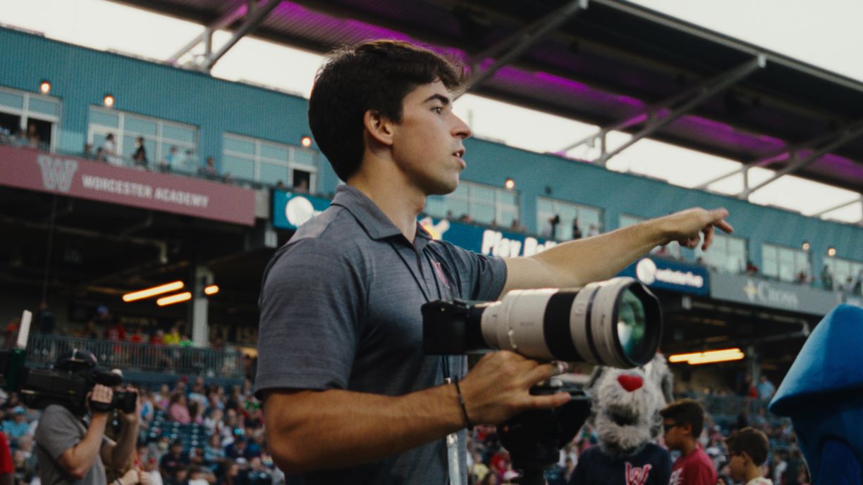 Eddie Monigan IV in stands at Polar Park baseball stadium, with video camera in hand