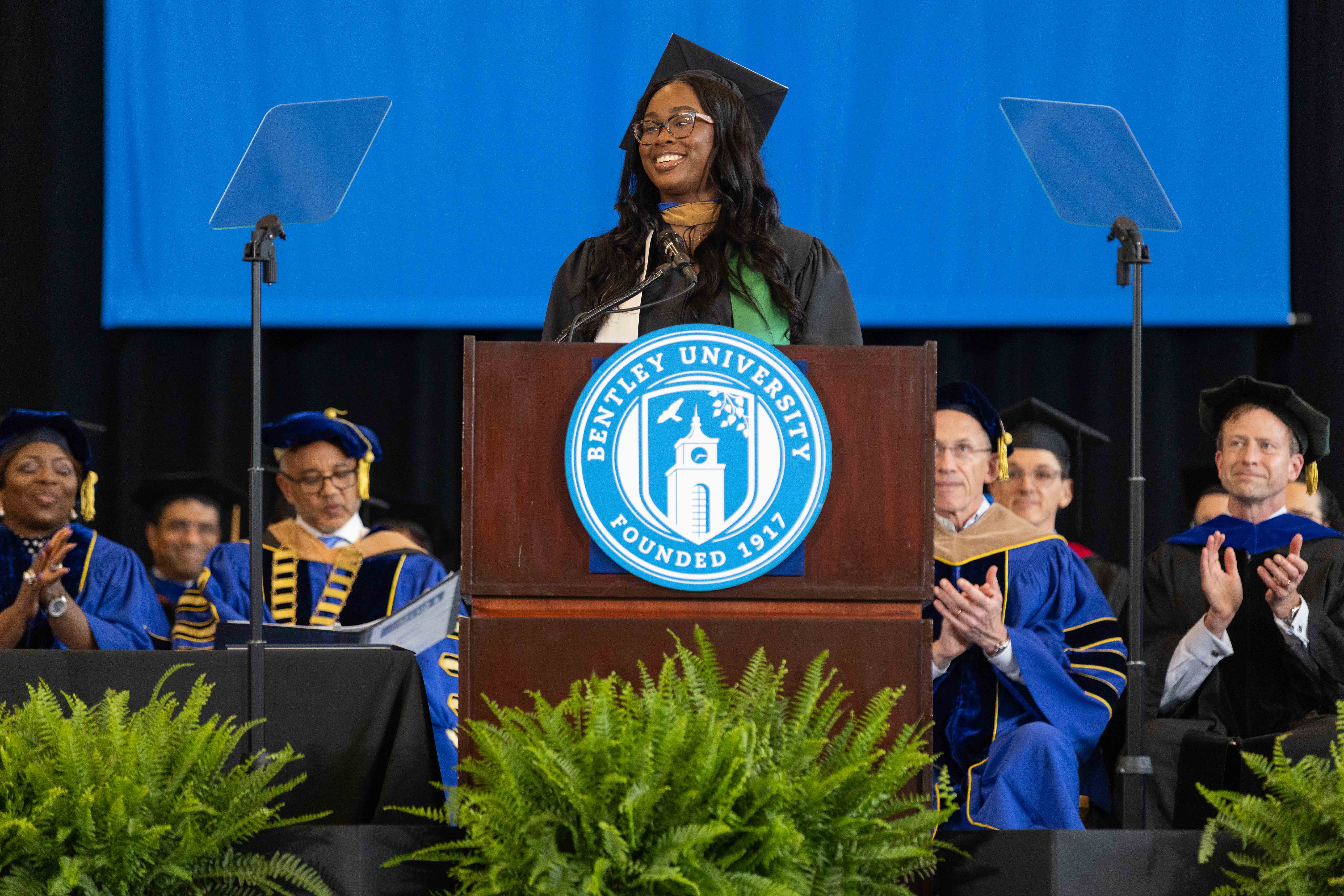 Aleshia Green '19 MSF '24 delivers her commencement address at the podium 