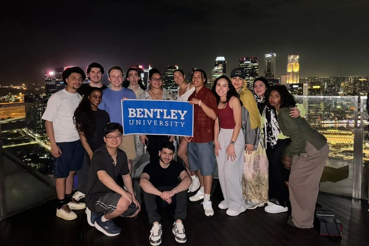 Bentley student cohort in an intensive course in Southeast Asia pose holding a Bentley sign