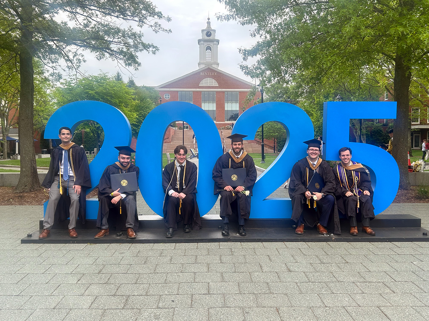 new grads pose next to giant letters spelling out 2025