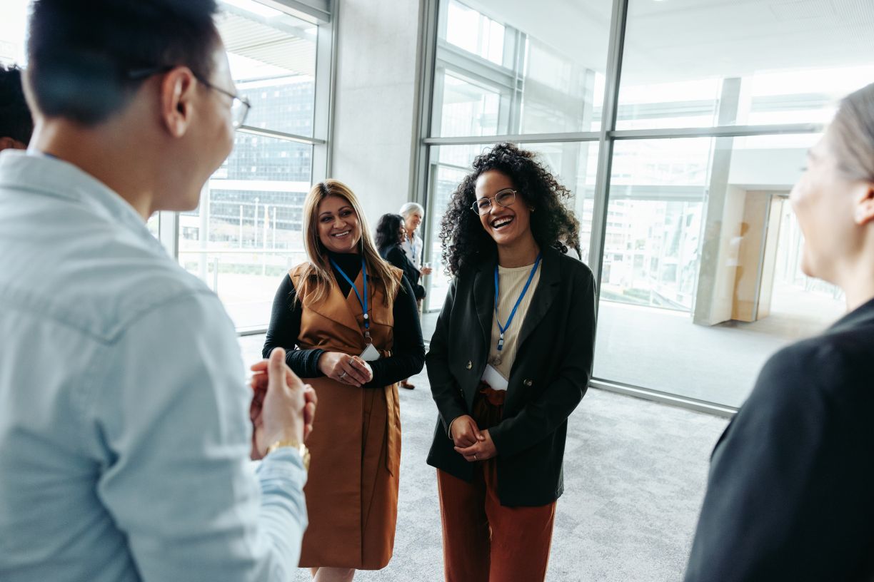 Two people, representing networking buddies, engage with another person at an event