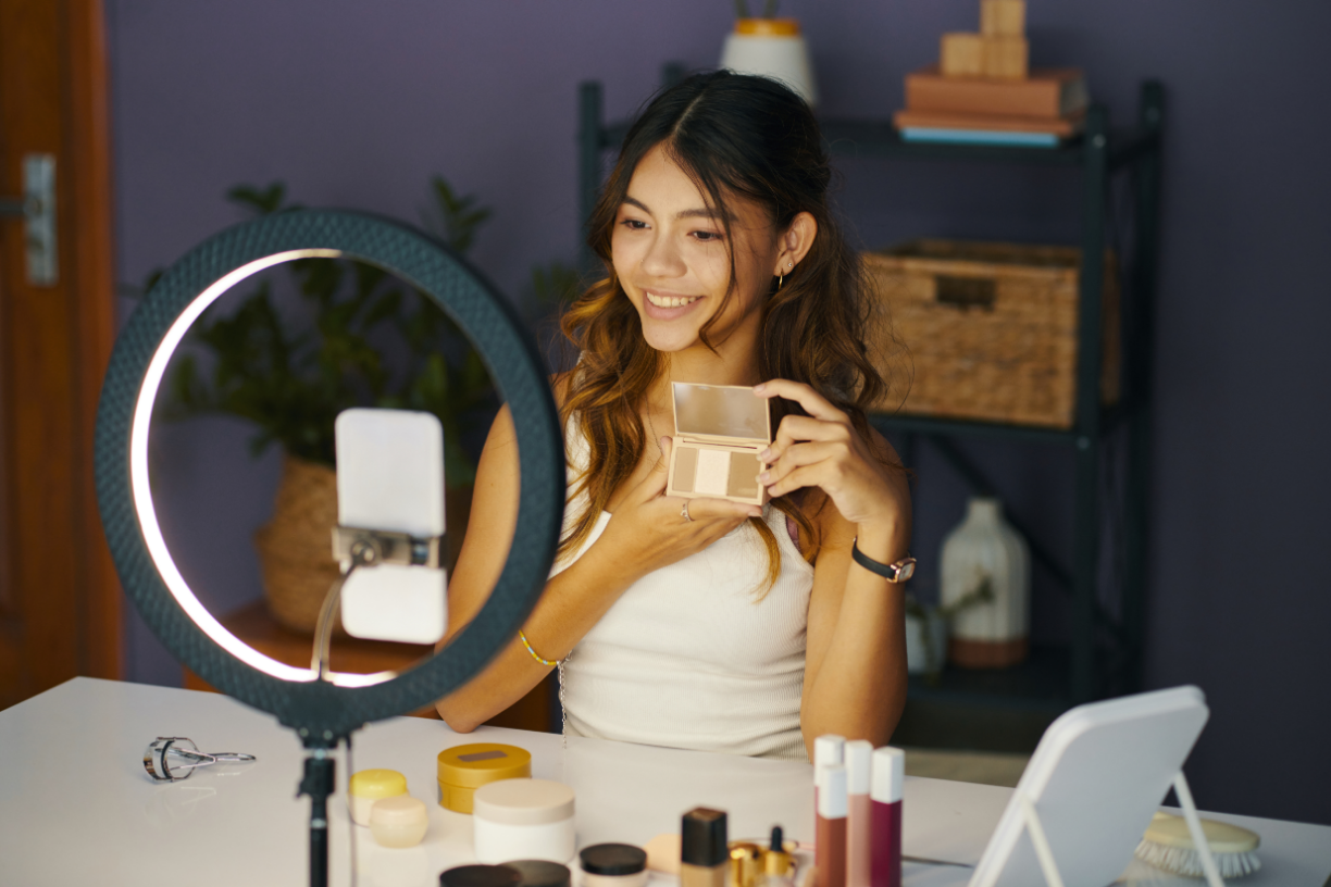 Smiling person filming blog, showing new cosmetics they bought online