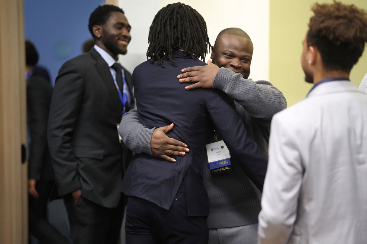 Attendees embrace at the Bentley Mankind Movement networking conference