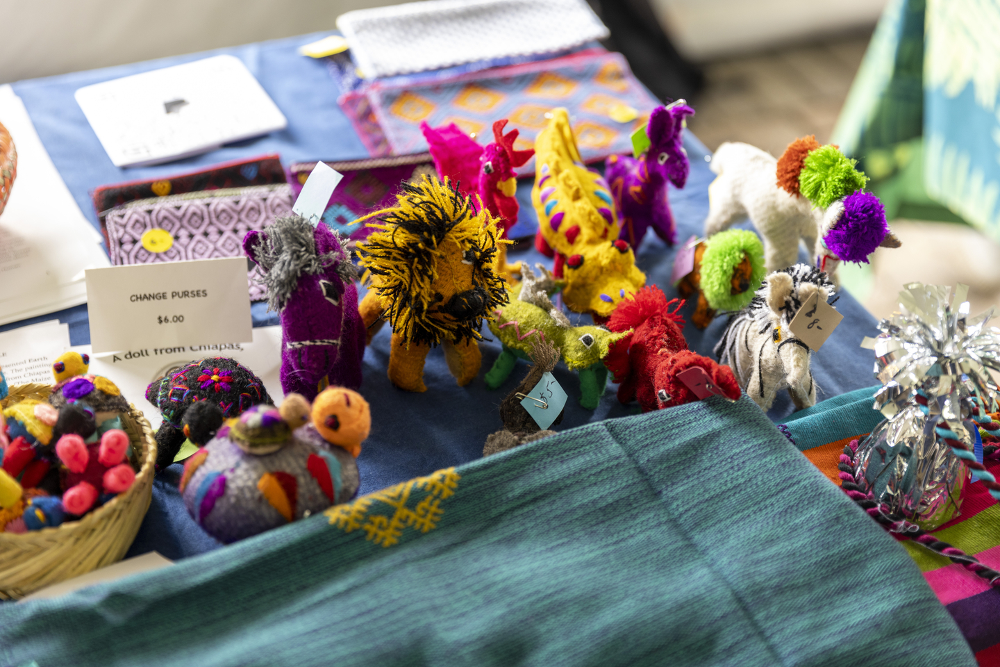 Colorful handmade fabric animals and items displayed on a table