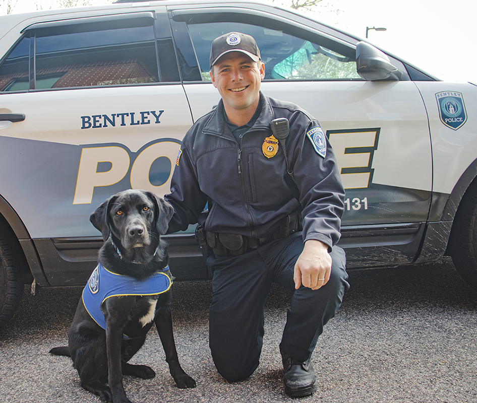 Blue the comfort dog with Sgt. Bartkus in front of a cruiser
