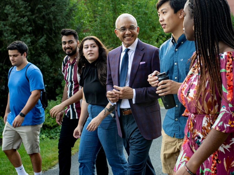President Chrite walking with students on campus