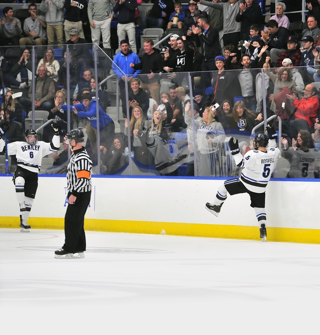 Ethan Roswell scores a hockey goal and celebrates