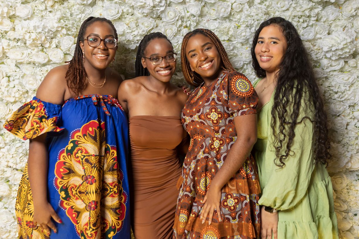 Group wearing African attire in front of floral wall