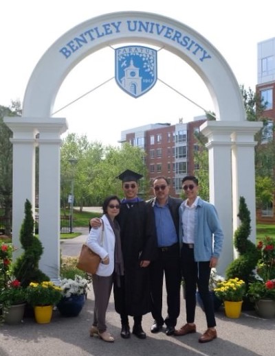 Jonathan Yu at his 2019 Bentley graduation, posing under an archway with his parents and younger brother 