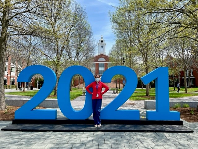 Jackie on campus in front of the 2021 sign