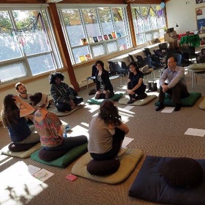 A group of people practice meditation in the Sacred Space.