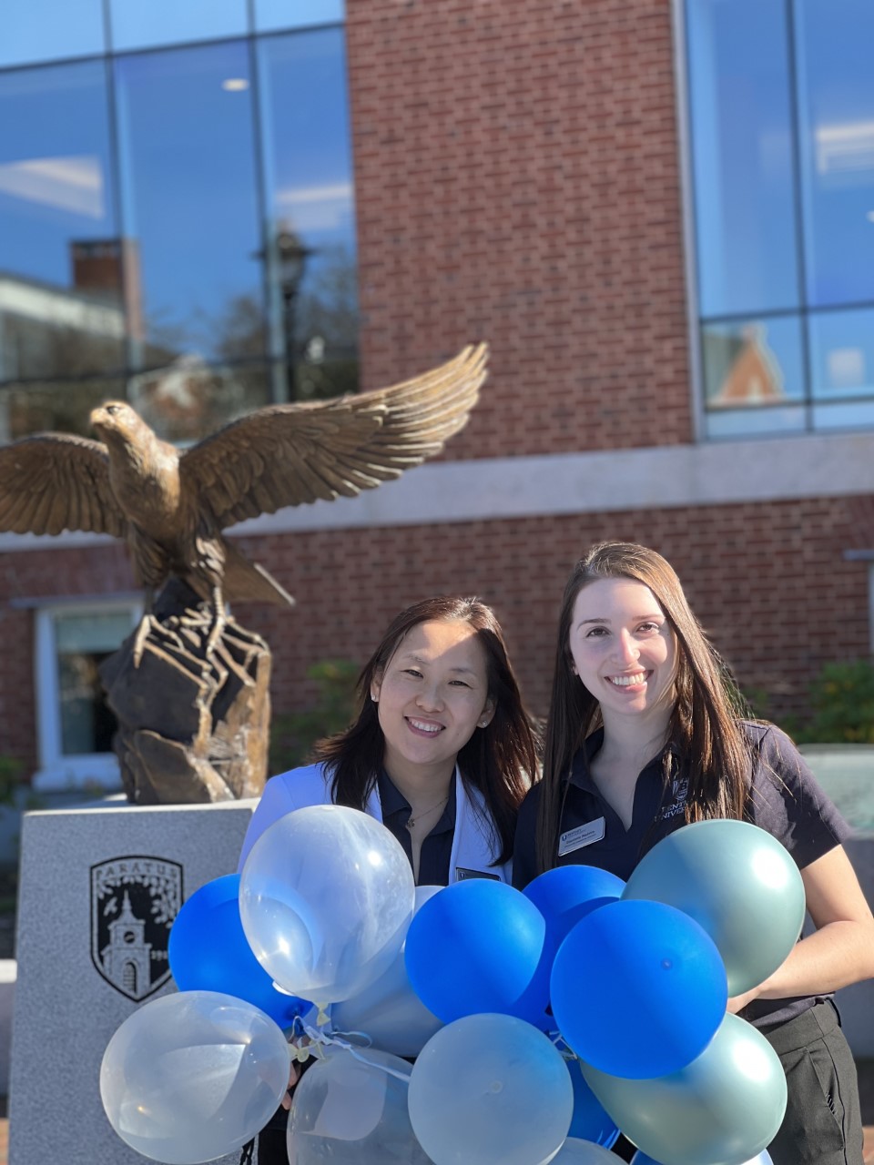 Graduate admission officers holding balloons in front of bentley library 