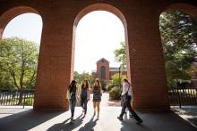 three bentley students walking through building on campus
