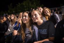 two female students cheering on Bentley's football team