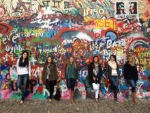 Six bentley students stand against a colorful graffiti wall in Prague, Czech Republic