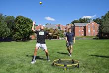 Students play spike ball on Bentley greenspace
