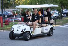 Bentley orientation leaders ride on a golf cart