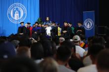 Singer on stage in front of crowd at Bentley Convocation