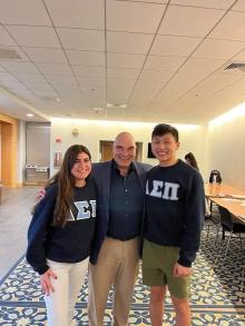 2 students in fraternity sweatshirts and a man