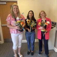Three people with flower arrangements