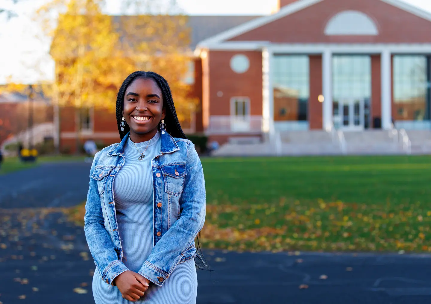Pearl Opara wearing blue dress with denim jacket in front of Bentley library