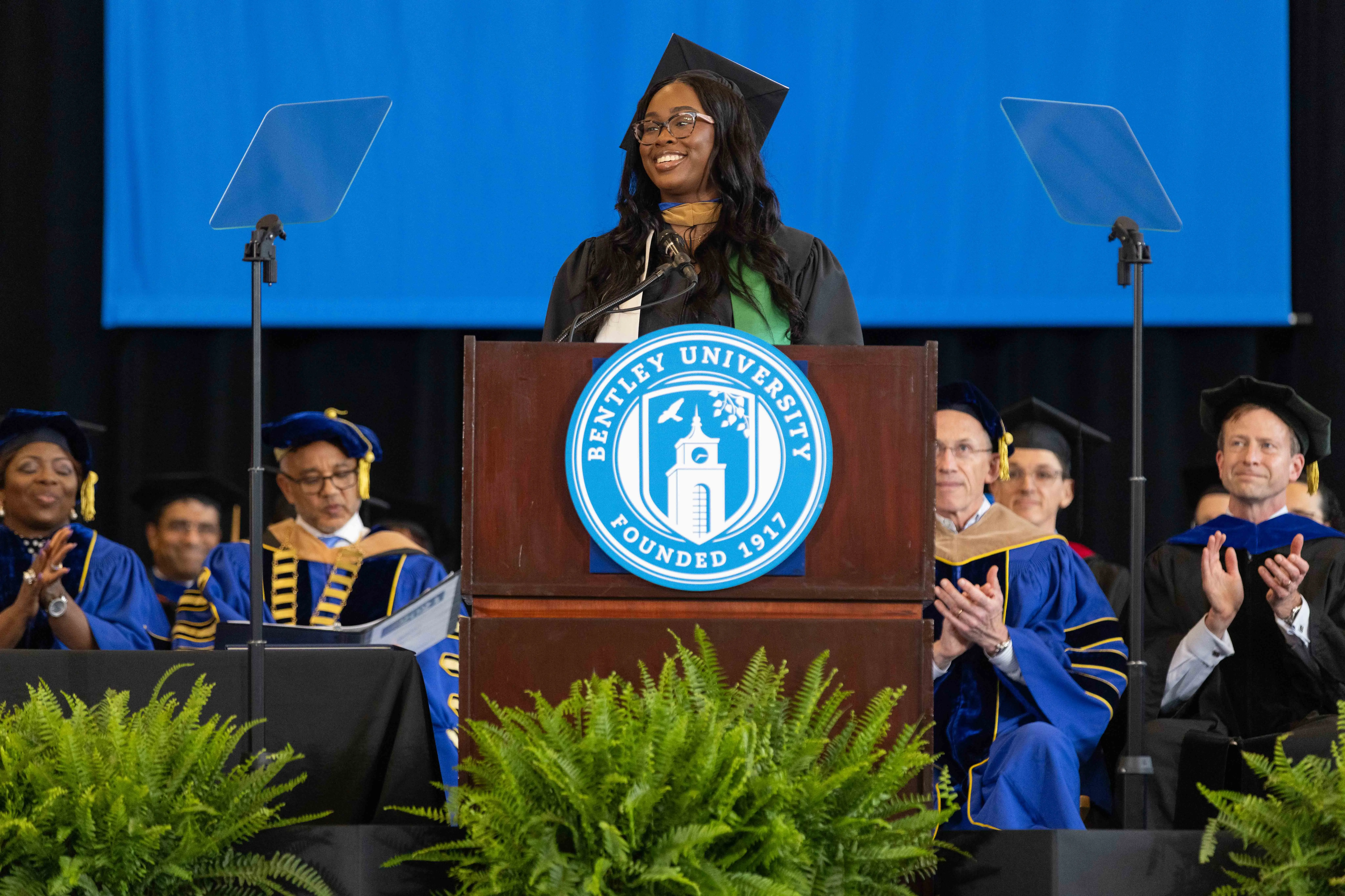 Aleshia Green '19 MSF '24 delivers her commencement address at the podium 
