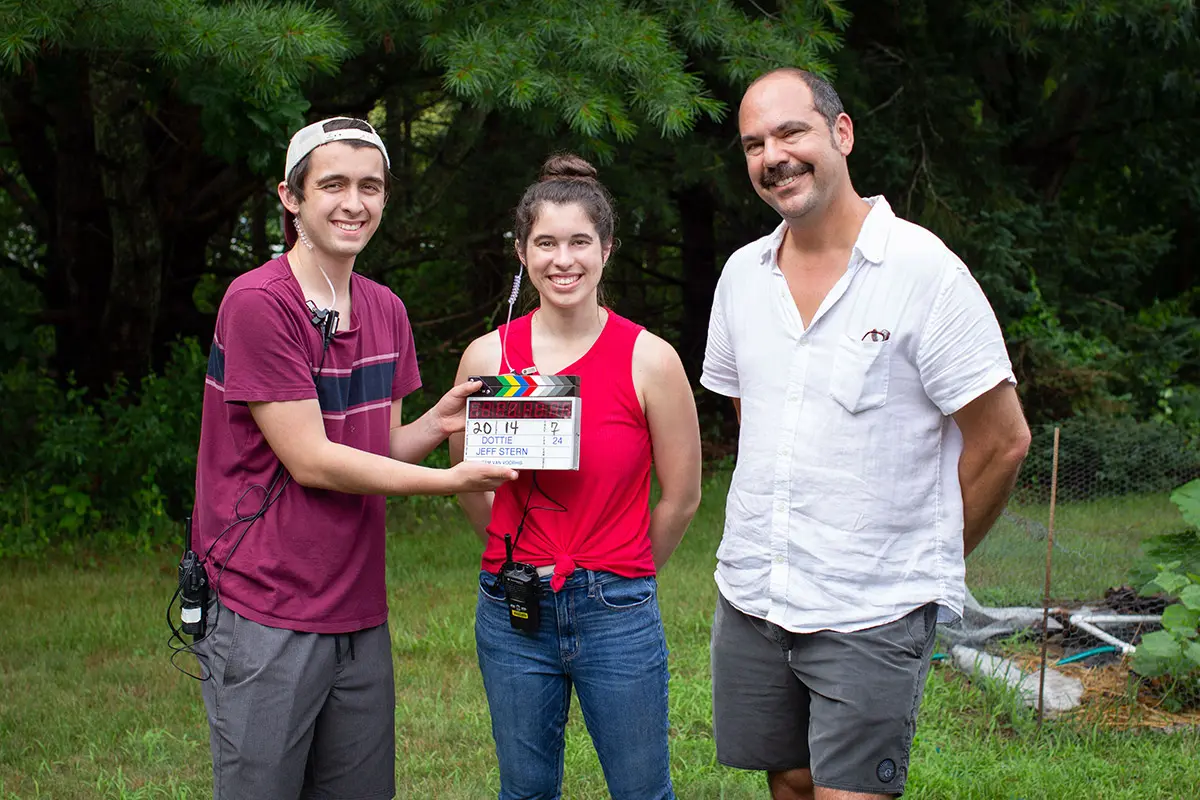 smiling group holding a clapperboard
