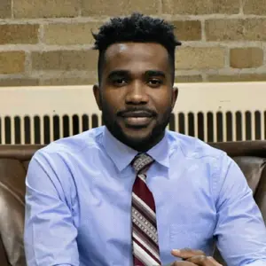 Victor Obetta wearing light blue shirt and striped tie