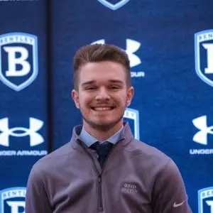 Calvin Polachek wearing a grey jacket over blue collared shirt
