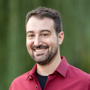 Luke Cherveny, Senior Lecturer in Mathematical Sciences and Director of the Master’s in Business Analytics, wearing a dark red button-down shirt over a black t-shirt