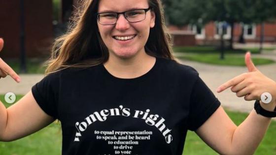 Student pointing to t-shirt reading "women's rights"