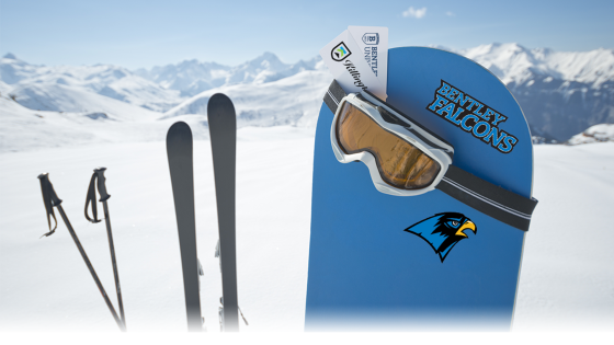Ski poles, skis and a snowboard with a "Bentley Falcons" sticker and a falcon sticker, with goggles and tickets