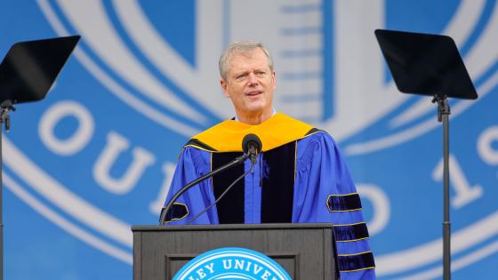 Charlie Baker speaks at a podium with the Bentley University logo behind him