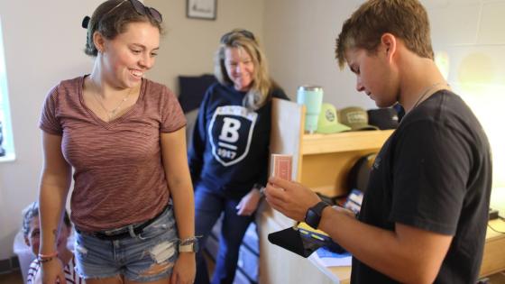 Two Bentley students with a mother in dorm