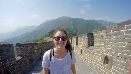 Student smiling with Great Wall of China and mountains 
