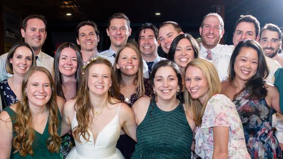 a group poses for a photo at a wedding