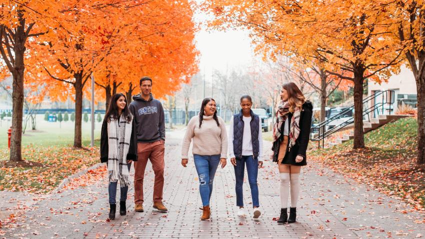 five students walk across campus