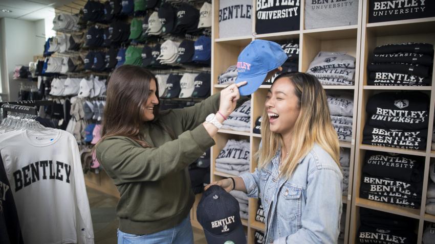 two students try on bentley apparel in bookstore 