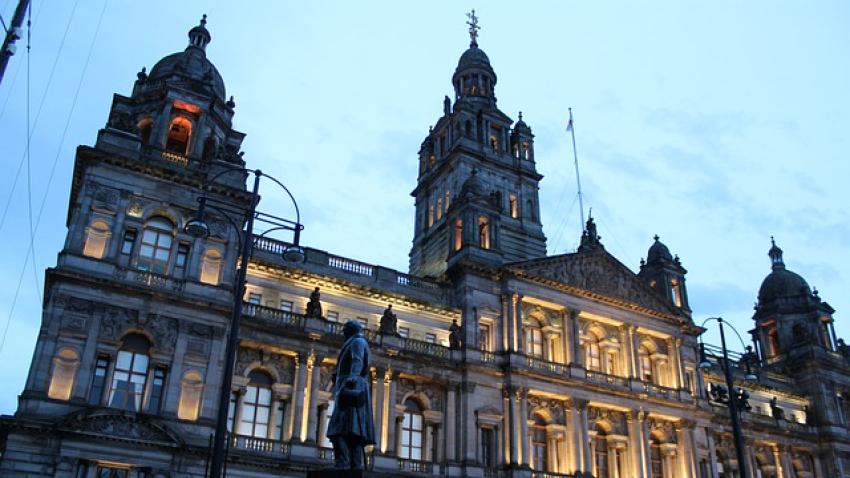Large building with intricate architecture and a statue of a man infront.