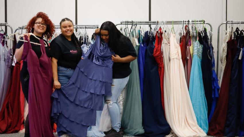 Three Bentley students arranging prom dresses