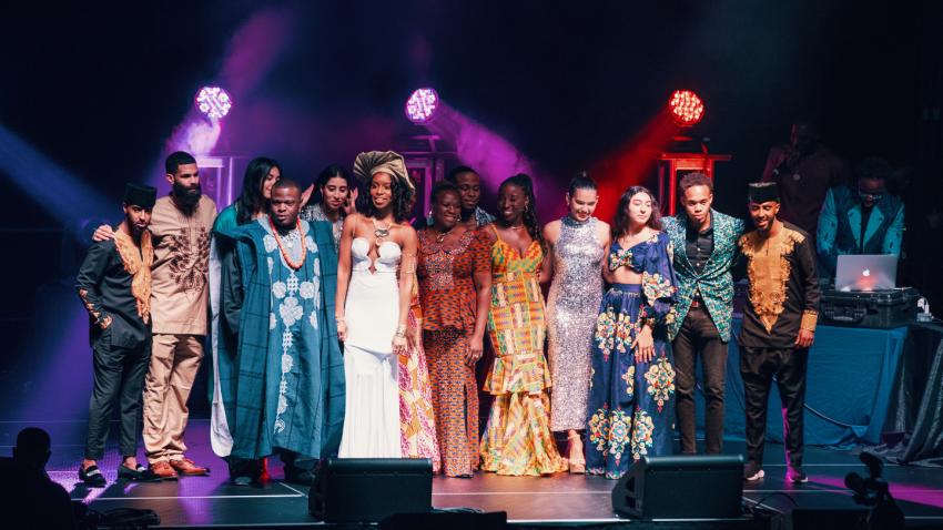 Bentley students and gala attendees on stage dressed in traditional African clothing 